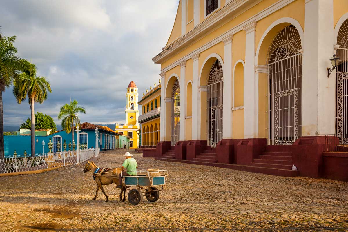 Church of the Holy Trinity overlooking Plaza Mayor, Trinidad – Photo: Shutterstock man on small horse wagon by a church building