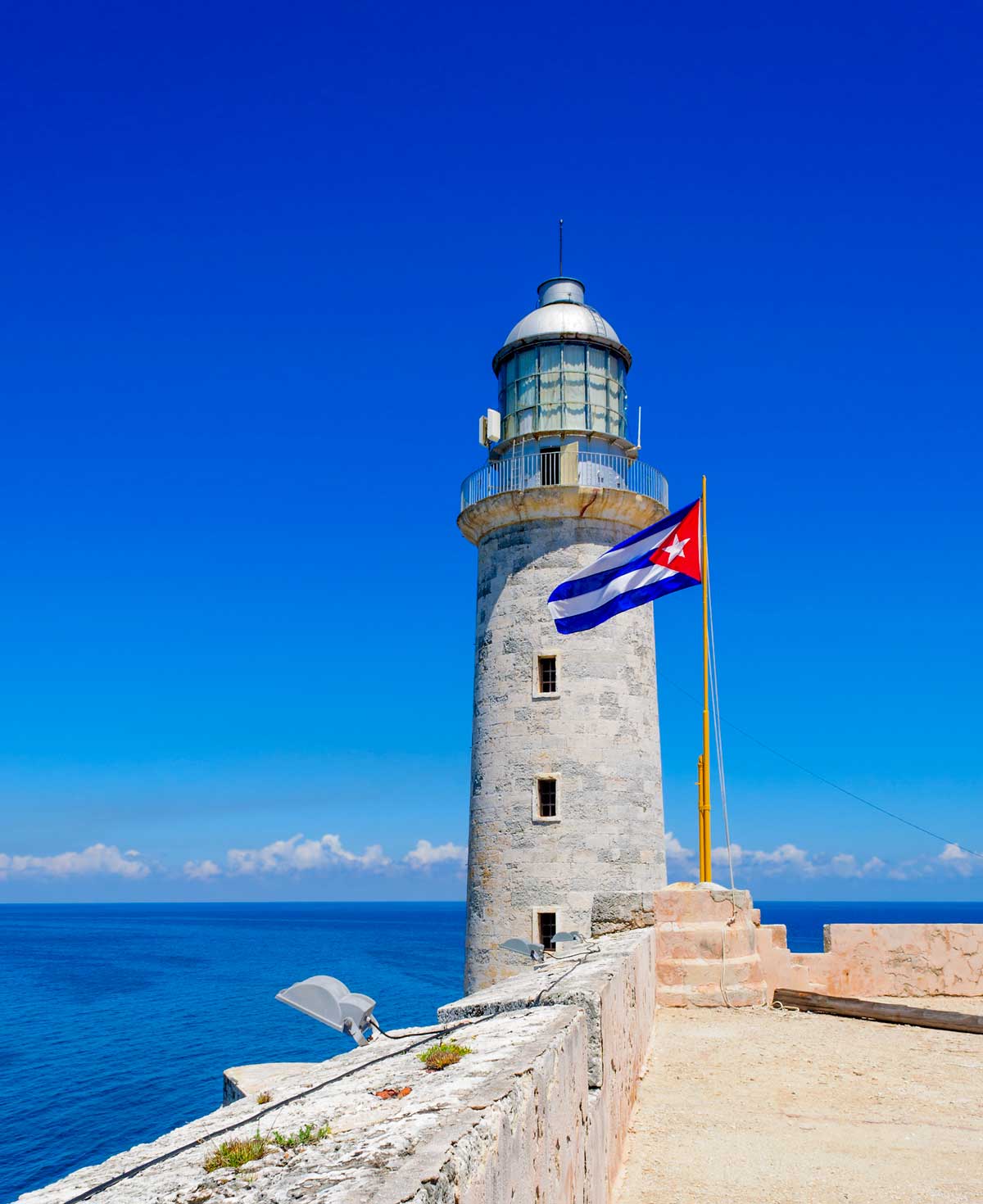 Lighthouse at Castillo del Morro, Havana – Photo: Shutterstock old lighthouse with cuban flag