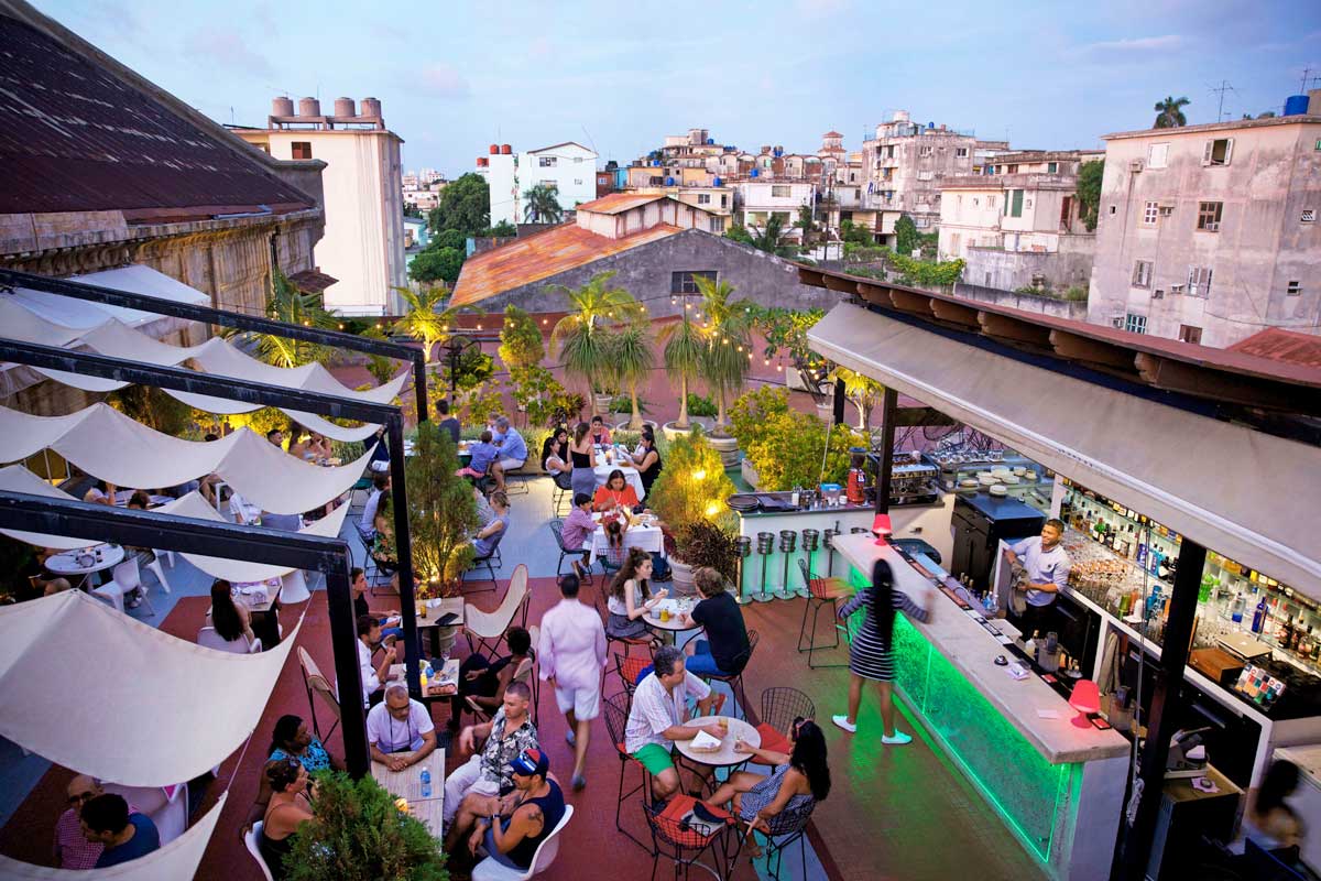 Terrace bar and dining area at Fábrica de Arte – Photo: Alamy rooftop bar with guests seated