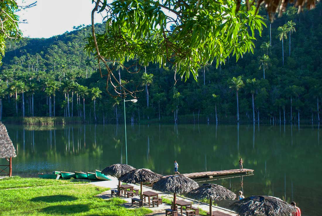 San Juan River, Sierra del Rosario nature reserve – Photo: Shutterstock river bank with canoes, grass lawn and mountains