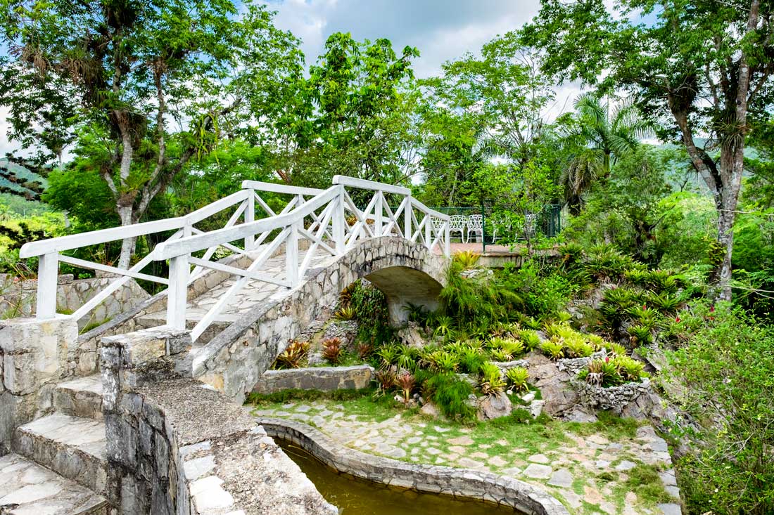 Soroa Orchid Botanical Gardens – Photo: Shutterstock small stone brigde over a pond in a garden environment
