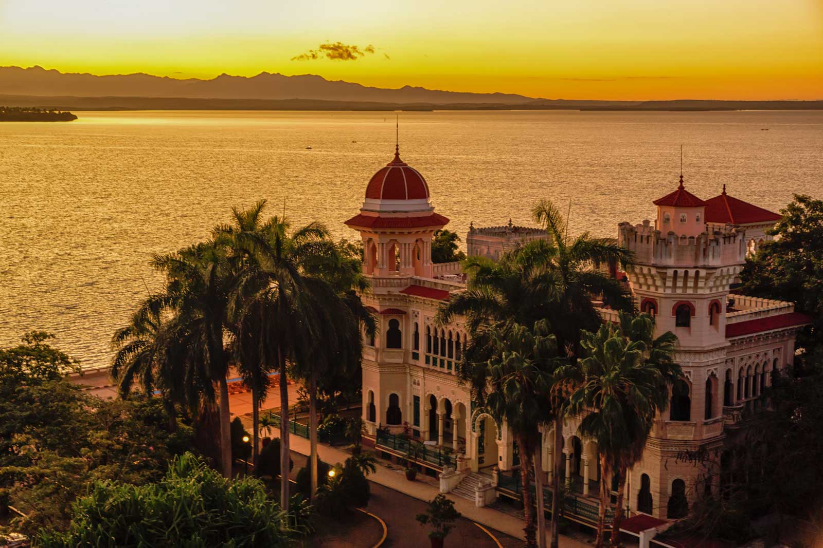 Sunset over Palacio de Valle, Cienfuegos – Photo: Shutterstock_hero large building in baroque style with palm trees by the ocean